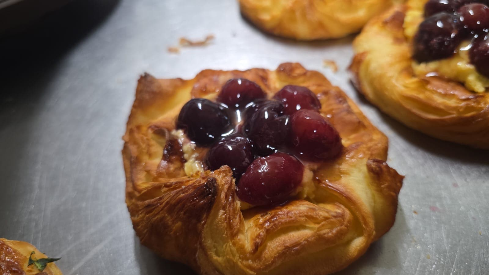 A cherry danish with glossy dark cherries set into custard