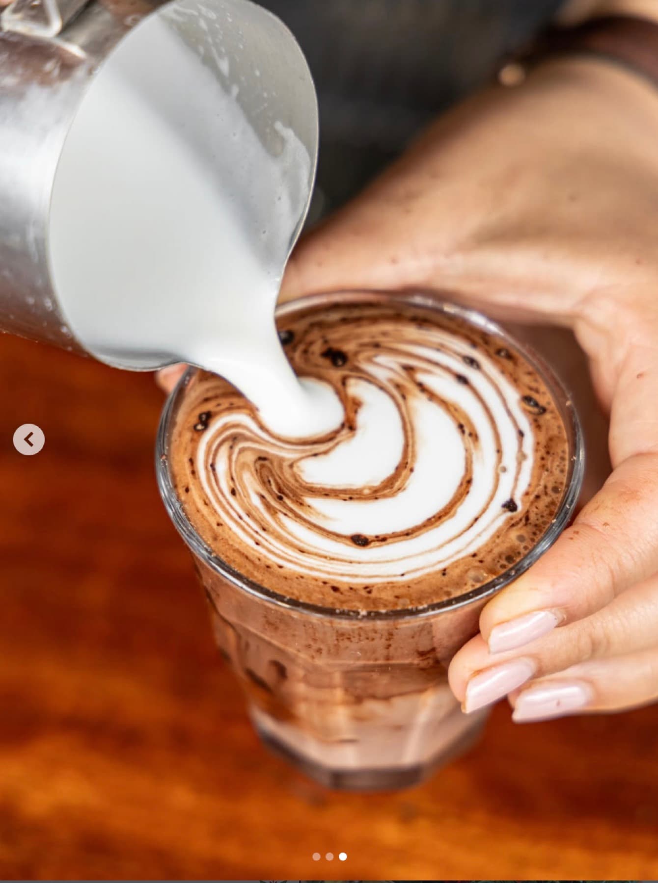 Milk poured over an iced mocha, marbling through the chocolate