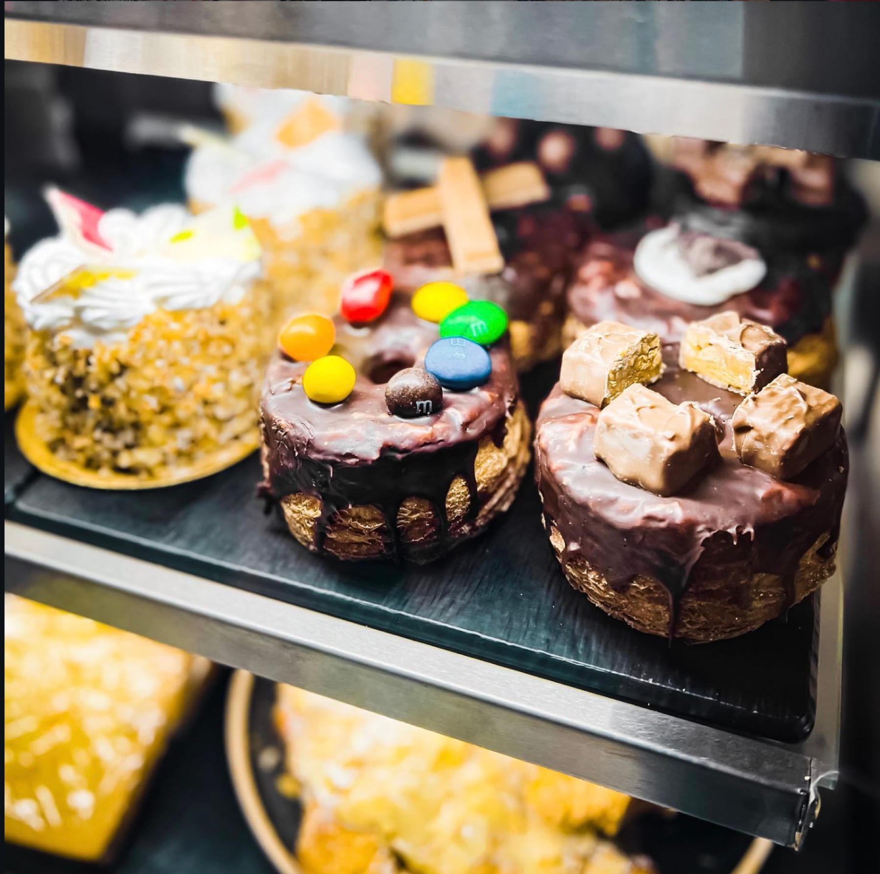 Individual chocolate cakes topped with wafers and confectionery in the cake cabinet