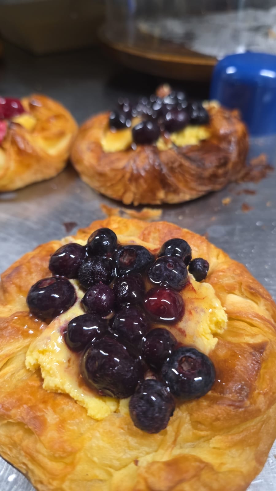 A blueberry custard danish with laminated pastry layers open at the edges