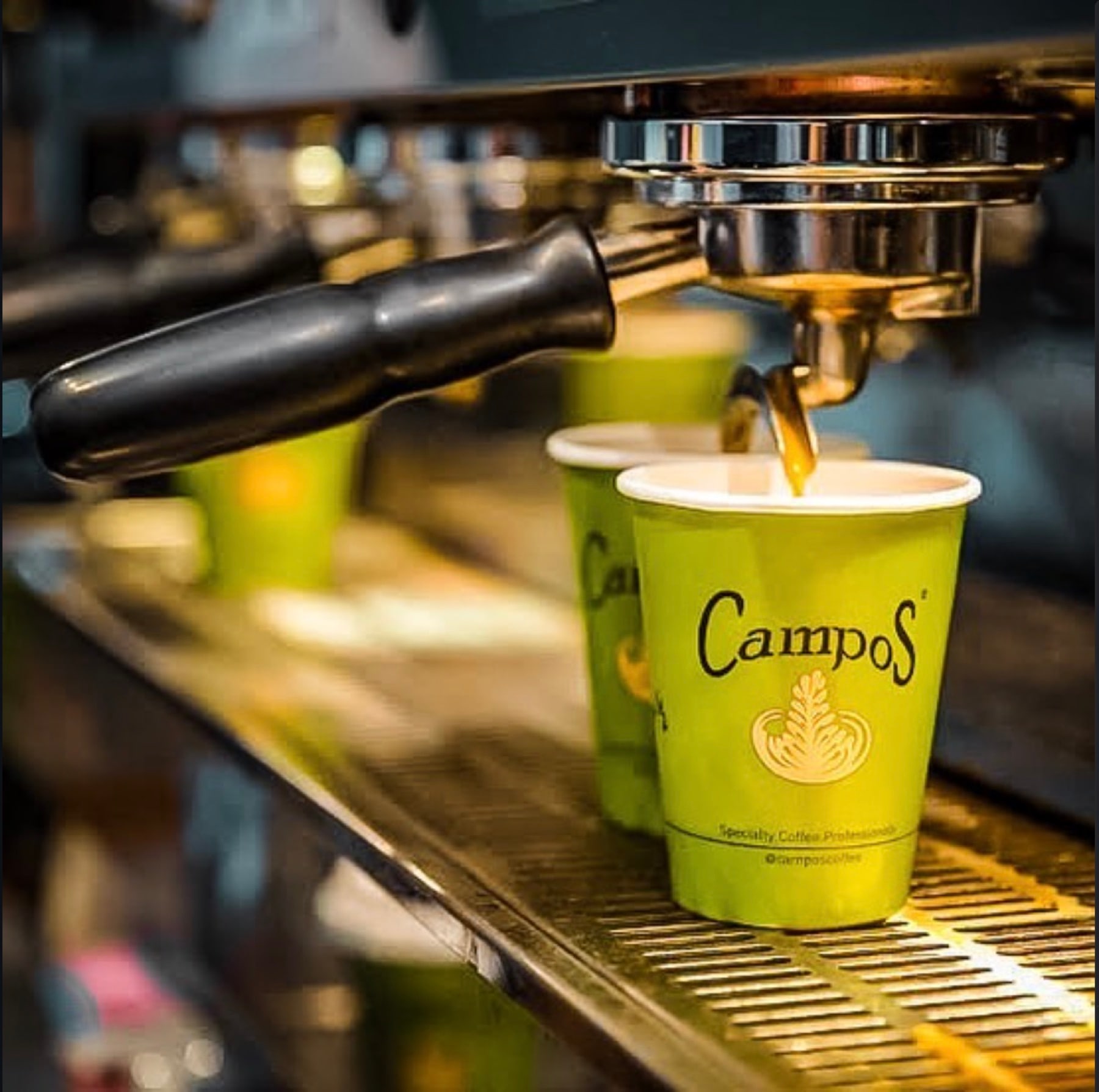 Espresso extracting from a group head into two takeaway cups
